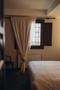 ein Schlafzimmer mit einem Bett und einem Fenster in der Unterkunft Hotel Restaurante Doña Anita in Requena