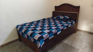 a bedroom with a bed with a blue comforter at SPOT ON Diamond Hotel in Rāmpura +2 photos