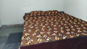 a bed with a brown and white blanket on it at SPOT ON Diamond Hotel in Rāmpura