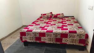 a bedroom with a bed with a red and white quilt at SPOT ON Diamond Hotel in Rāmpura
