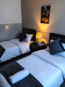 een kamer met twee bedden en een lamp op een tafel bij Kahraman Amman Hotel in Amman +44 foto's