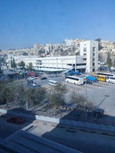 een parkeerplaats met een groot gebouw op de achtergrond bij Kahraman Amman Hotel in Amman