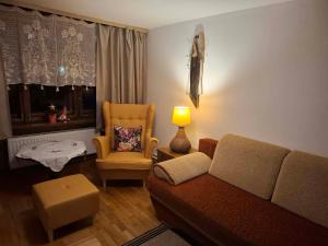 a living room with a couch and a chair at Willa Aśka in Karpacz