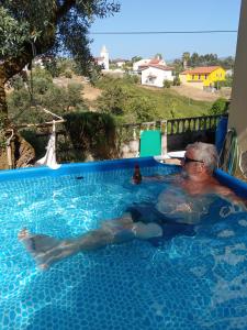 een oudere man die in een zwembad ligt bij Casa da Casimira in Miranda do Corvo