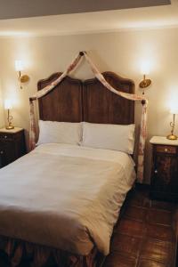 ein Schlafzimmer mit einem großen Bett mit einem hölzernen Kopfteil in der Unterkunft Hotel Restaurante Doña Anita in Requena