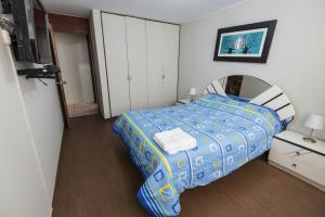 - une chambre avec un lit doté d'une couette bleue et jaune dans l'établissement Departamento Temporal Pardo, à Lima