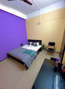 a bedroom with a bed and a purple wall at Letstay in Guwahati