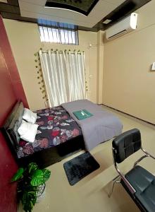 a room with a bed and a chair in it at Letstay in Guwahati