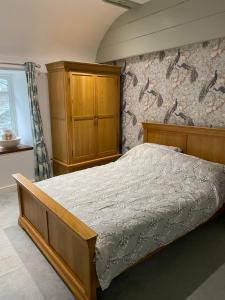 a bedroom with a bed and a wooden cabinet at The chapel in Machynlleth