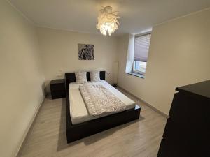 a bedroom with a bed and a chandelier at Apartment with panoramic view in Lipperscheid
