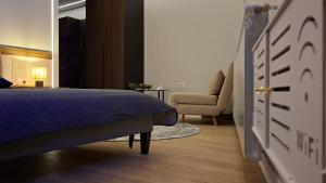 een slaapkamer met een blauw bed en een stoel bij Respiro Villas in Tîrgu Neamţ