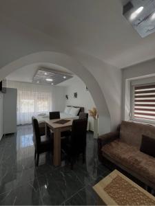 een eetkamer met een tafel en een bank bij Sobe i Apartmani Casa Mia in Pećinci +54 foto's