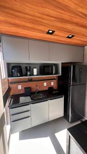 a small kitchen with a sink and a refrigerator at High Standard Two Bedroom Apartment Private Pool Frances Beach Garden 209 in Marechal Deodoro
