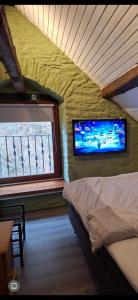 een slaapkamer met een bed en een tv aan de muur bij joseph in Monschau