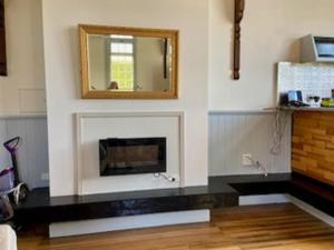 un soggiorno con camino e specchio di Convent Franklin - Schoolhouse Apartment a Franklin