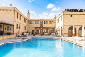 een groot zwembad in een gebouw met mensen er omheen bij Ciner Hotel in Goreme