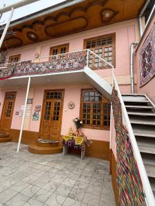 un edificio con scala e tavolo di fronte ad esso di Istirohat guest house a Samarkand