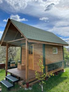 een houten hut met een terras in het gras bij Agroturystyka u Dudków- Balia i Apiterapia in Jeleśnia
