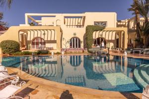ein großes Schwimmbad vor einem Gebäude in der Unterkunft Villa Riadana in Agadir