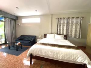 ein Schlafzimmer mit einem großen Bett und einer Couch in der Unterkunft Khaolak Beachhouse Kelolo in Khao Lak