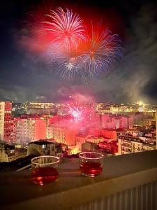 twee glazen die bovenop een balkon staan met vuurwerk bij Mameli View Cagliari in Cagliari