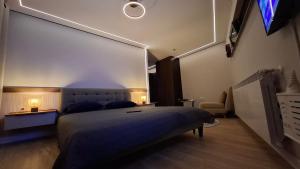 ein Schlafzimmer mit einem großen Bett und einer blauen Decke in der Unterkunft Respiro Villas in Târgu Neamţ