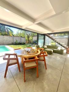 a living room with a table and chairs and a pool at Jungle surf Villa in El Zonte