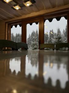 a dining room table with chairs and a view of trees at Spadok Forest Villas - Villa 2 in Sloboda