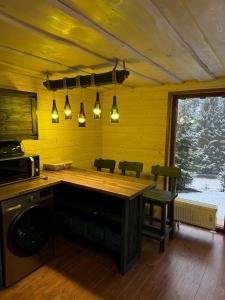 a kitchen with a table and chairs and lights at Spadok Forest Villas - Villa 2 in Sloboda
