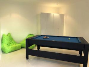 een pooltafel in een kamer met een groene bank bij Coastal Chic with Heated Pool Quiet Location in Sunshine Beach +4 foto's