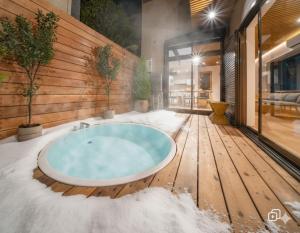 ein Whirlpool auf einer Holzterrasse mit Schnee in der Unterkunft 華ならまち in Nara + 47 Fotos