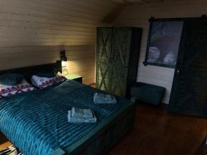 a bedroom with a bed with two towels on it at Spadok Forest Villas - Villa 2 in Sloboda