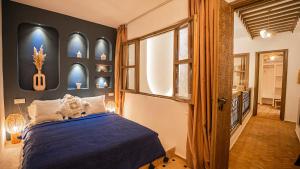 a bedroom with a blue bed and a window at Riad Alaya, Rooftop Pool & Koutoubia View in Marrakesh