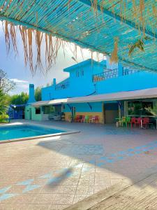un bâtiment bleu avec une piscine, des tables et des chaises dans l'établissement Hotel Complex Europe, à Guercif