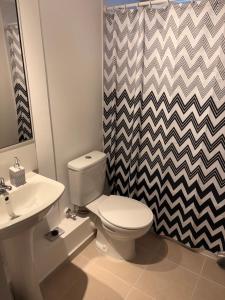 een badkamer met een wit toilet en een wastafel bij Comodo y cercano a la playa in Coquimbo