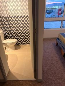 een badkamer met een toilet en een raam bij Comodo y cercano a la playa in Coquimbo +2 foto's
