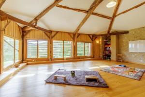 Elle comprend un salon doté de plafonds en bois et de fenêtres. dans l'établissement Gite de Marbois, 