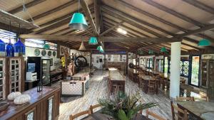 a restaurant with tables and chairs in a room at Atelie Hospedagem in Palhoça