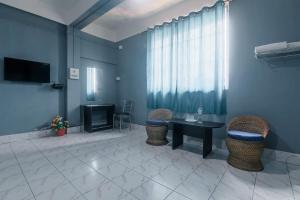 een kamer met een tafel, stoelen en een televisie bij Hotel O SPRINGVILLA in Dispur