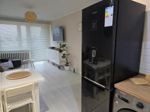een keuken met een zwarte koelkast in een kamer bij Apartment Cherry in Gryfice