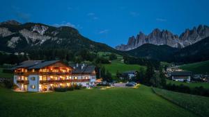 ein Haus auf einem Hügel mit Bergen im Hintergrund in der Unterkunft Proihof in Villnöss
