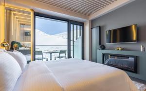 een slaapkamer met een bed, een open haard en een tv bij New Gudauri Atrium Apartments in Goedaoeri