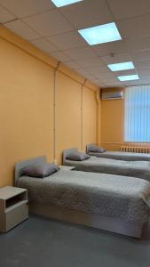 three beds in a room with yellow walls at Трініті Хаус in Kyiv