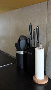 a container of utensils on a counter with a roll of toilet paper at Трініті Хаус in Kyiv