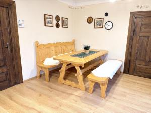 een houten tafel met een bank en een tafel en stoel bij Przystanek Rabka - Domek całoroczny in Rabka