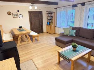een woonkamer met een bank en een tafel bij Przystanek Rabka - Domek całoroczny in Rabka