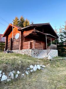 una baita di tronchi situata in cima a un campo di Sunset Chalet a Ciocanu