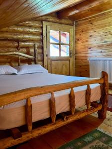 una camera con un letto in una baita di tronchi di Sunset Chalet a Ciocanu