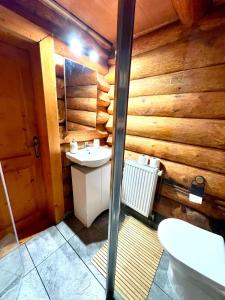 bagno con lavandino e parete in legno di Sunset Chalet a Ciocanu Altre 19 foto