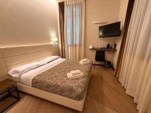 una camera d'albergo con un letto e due asciugamani di Arena Luxury Suite a Verona